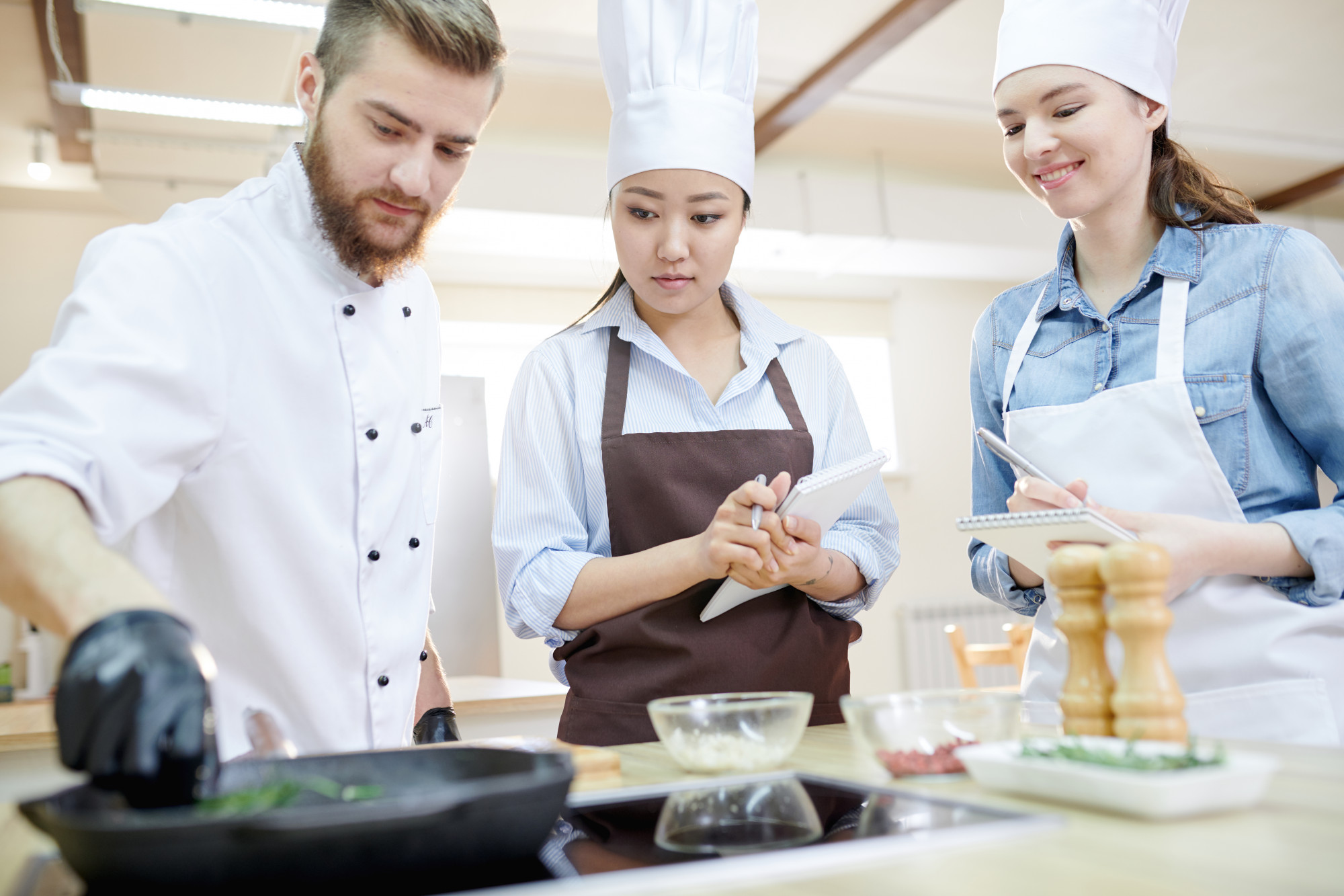 Workshop chef demonstrating technique to students